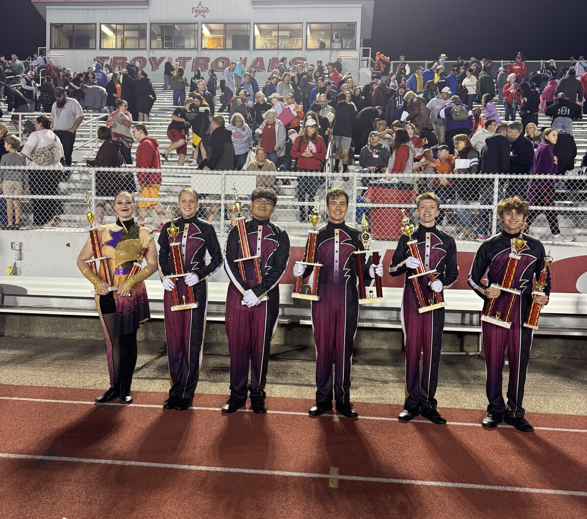 FH Bands members hold trophies on a track